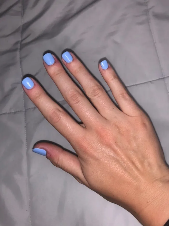 A finished iLash manicure in glossy periwinkle blue